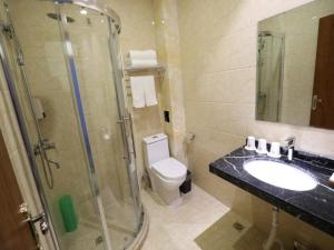 ein Bad mit einer Dusche, einem WC und einem Waschbecken in der Unterkunft Shell Taiyuan City Xiaodian District Zhenwu Road Hotel in Taiyuan