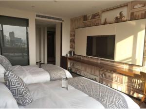a bedroom with two beds and a flat screen tv at GME Huainan Tianjiaan District Chaoyang East Road Hotel in Huainan