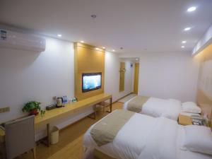 Cette chambre comprend deux lits et une télévision. dans l'établissement GreenTree Inn Hefei Feixi County South Jinzhai Road Jinyun International Business Hotel, à Sanshigang