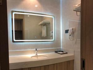 een badkamer met een wastafel en een spiegel bij GreenTree Eastern Huai'an Railway Station Mandu Plaza Hotel in Huai'an