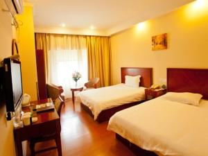 南京市にあるGreenTree Inn Jiangsu Nanjing Olympic Sports Center Express Hotelのベッド2台とテレビが備わるホテルルームです。