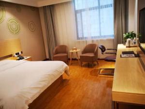a hotel room with a bed and a desk and chairs at GreenTree Inn Zaozhuang Xuecheng Qilianshan Road Business Hotel in Taozhuang