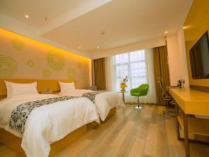 a hotel room with two beds and a flat screen tv at GreenTree Inn Tongchuan Yaozhou District New District Hospital Business Hotel in Yaozhou