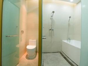 two images of a bathroom with a toilet and a shower at GreenTree Eastern Rizhao High Speed Railway Station Hotel in Rizhao