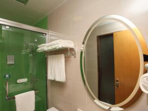 baño con espejo y ducha con toallas en GreenTree Inn Hefei Huainan Road Huaihe Garden Express Hotel, en Hefei