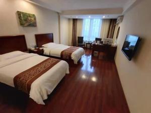 een hotelkamer met 2 bedden en een flatscreen-tv bij GreenTree Inn Shanghai Jiading Dazhong International Auto City Business Hotel in Jiading