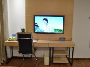 a television sitting on top of a desk with a chair at Vatica Xuzhou Suining Bus Station Bayi West Road Hotel in Suining