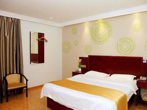 um quarto de hotel com uma cama grande e uma cadeira em GreenTree Inn Shanghai Minhang Jiaoda Dongchuan Road Shell Hotel em Xangai