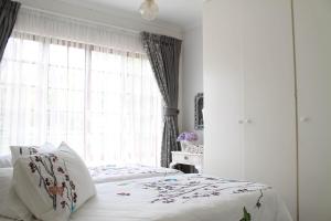 1 dormitorio con 2 camas y ventana en Lincoln Cottages BnB & Self-Catering, en Pietermaritzburg