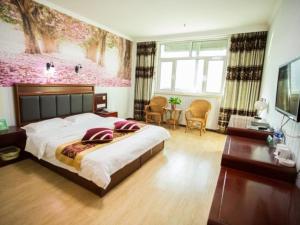 a bedroom with a large bed with a pink wall at Green Alliance Langfang Xianghe County Xiushui Street PengDa furniture city Hotel in Langfang