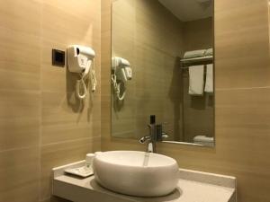 a bathroom with a sink and a mirror at GreenTree Inn Dongfang City Dongfang Avenue High-speed Railway Station Express Hotel in Dongfang