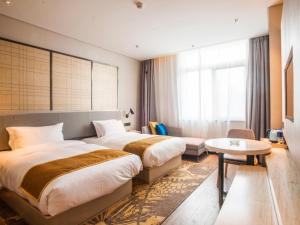 a hotel room with two beds and a table at GreenTree Eastern Lianyungang Jiaruibao Plaza Hotel in Lianyungang
