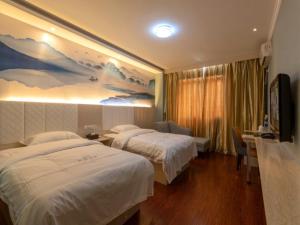 Shell Maanshan City Hanshan County Huanfeng North Road City Center Hotel tesisinde bir odada yatak veya yataklar