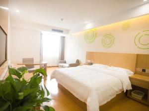 een slaapkamer met een groot wit bed en een tafel bij GreenTree Inn Fuyang Linquan County Yiwu Trade City Express Hotel in Jinzhuang