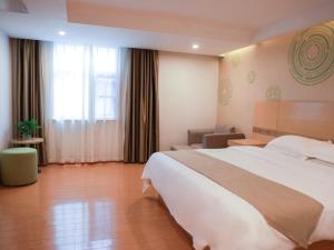 a hotel room with a large bed and a large window at GreenTree Inn Xianning Tongcheng Bus Station Business Hotel in Tongcheng