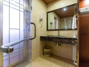 a bathroom with a shower and a sink and a mirror at GreenTree Inn Lanzhou Railway Station East Road Business Hotel in Lanzhou