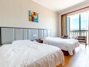 Cette chambre comprend 2 lits et une fenêtre. dans l'établissement GreenTree Alliance Zhejiang Zhoushan Haitian Avenue West Donghai Road Hotel, à Zhoushan