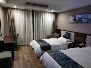 a hotel room with two beds and a desk at Shell Fuyang City South Bus Station Hotel in Fuyang