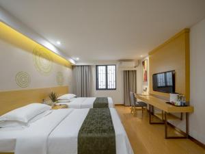 Habitación de hotel con 2 camas y escritorio en GreenTree Inn Wuxi Yixing Xushe Town Government Express Hotel en Yixing