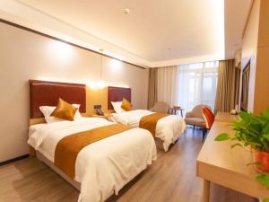 a hotel room with two beds and a table at Gya Yangzhou Slender West Lake Hotel in Yangzhou