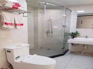 a bathroom with a shower and a toilet and a sink at Shell Lianyungang Donghai County Crystal City Shichen Road Hotel in Donghai