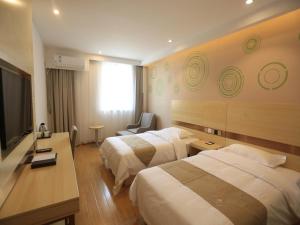 a hotel room with two beds and a flat screen tv at GreenTree Inn Anqing City Yixiu Government District University City Express Hotel in Anqing