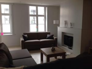 a living room with a couch and a fireplace at Holiday Home t' Keerske in Bruges