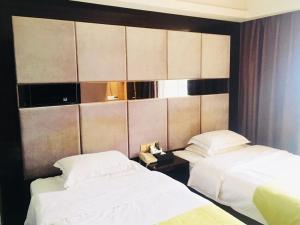 duas camas num quarto de hotel com lençóis brancos em GreenTree Alliance Ganzhou City Ningdu County Meijiang Town Sanhuan South Road Hotel em Ningdu