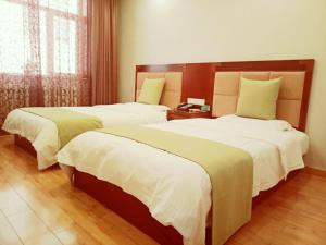 ZhalantunにあるGreenTree Alliance Hulunbeier Zhalantun Railway Station Hotelのベッド2台と電話があるホテルの部屋 +21枚の写真