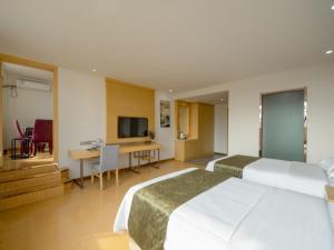 Habitación de hotel con 2 camas y escritorio en GreenTree Inn Wuxi Yixing Xushe Town Government Express Hotel en Yixing