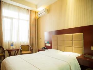 ein Hotelzimmer mit einem großen Bett und einem Fenster in der Unterkunft GreenTree Inn Jiayuguan Xinhua South Road Express Hotel in Jiayuguan