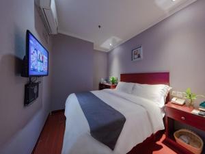 1 dormitorio con 1 cama grande y TV de pantalla plana en GreenTree Inn JiangSu NanJing MaQun Street NingZhi Road Shell Hotel, en Jiangning