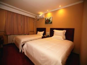 BaitalingにあるGreenTree Inn Hebei Qinhuangdao Olympic Center Express Hotelのベッド2台と窓が備わるホテルルームです。