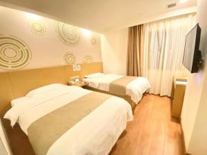 GreenTree Inn Tianjin Xiqing District Xiuchuan Road Sunshine 100 tesisinde bir odada yatak veya yataklar