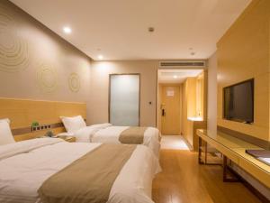 合肥市にあるGreenTree Inn Hefei Binhu District Hangzhou Road Expressway Times Square Business Hotelのベッド3台、薄型テレビが備わるホテルルームです。