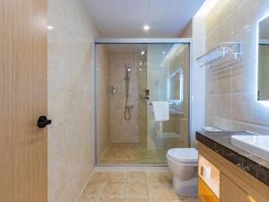 a bathroom with a shower and a toilet and a sink at Gya Jiaxing City Haiyan County Chang'an South Road Lishi Plaza Hotel in Jiaxing