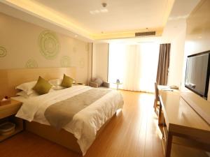 a bedroom with a large bed and a flat screen tv at GreenTree Inn Suzhou Yongqiao District Fuxiao Avenue Hotel in Suzhou