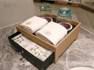 a box with towels and bowls on top of it at GreenTree Eastern Yancheng Binhai Oubaoliya City Square Hotel in Binhai +41 photos