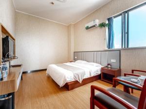A bed or beds in a room at GreenTree Alliance Zhejiang Zhoushan Haitian Avenue West Donghai Road Hotel