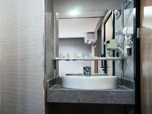 a bathroom with a sink and a mirror at Green Alliance Baoshan Shanghai University Qihua Road Metro Station in Shanghai