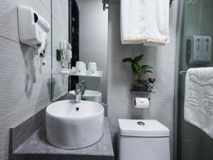 a bathroom with a sink and a toilet at Green Alliance Baoshan Shanghai University Qihua Road Metro Station in Shanghai