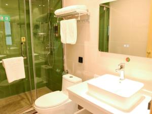 a bathroom with a toilet and a sink and a shower at GreenTree Inn Baoding Gaobeidian Baigou Express Hotel in Baoding