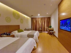 een hotelkamer met 2 bedden en een flatscreen-tv bij GreenTree Inn Huanggang Qichun County Ouyada Square Express Hotel in Qichun