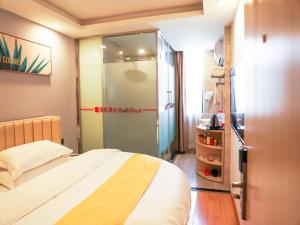 a bedroom with a bed and a sliding glass door at Shell Bozhou Woyang County Donghuan Road Hotel in Guoyang