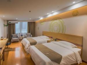 Cette chambre comprend deux lits et un bureau. dans l'établissement GreenTree Inn Linyi Shuixian Bus Station Business Hotel, à Yishui