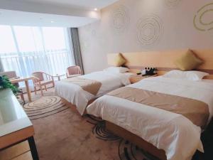 um quarto de hotel com duas camas e uma mesa em GreenTree Inn Huainan Shannan New District Erzhong Business Hotel em Sanhe