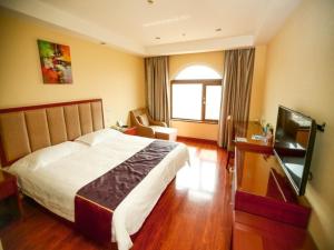a hotel room with a bed and a television at GreenTree Inn Shandong Qingdao Wuyishan Road Jiashike Shopping center Business Hotel in Huangdao +15 photos