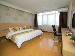 a hotel room with a large bed and a television at GreenTree Inn Binzhou Yangxin County Bus Station Lubei Da Market Business Hotel in Binzhou