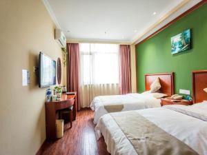 GreenTree Inn JiangSu Zhenjiang Danyang Wanshan Park Express Hotel في Danyang: غرفه فندقيه سريرين وتلفزيون