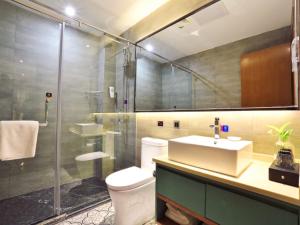 a bathroom with a toilet and a sink and a shower at GME Rizhao Jinan Road Sun Plaza Hotel in Rizhao